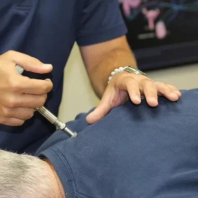 Dr. Ryan Hanson using an Activator for gentle precision chiropractic.