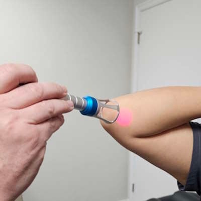 Dr. Justin McGinn using Class IV laser for elbow pain relief in Edmond.