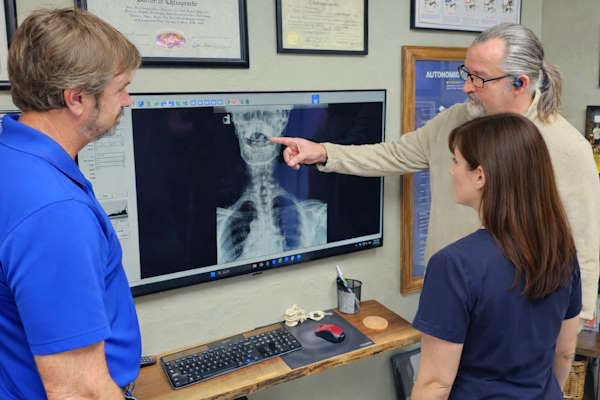 Chiropractors and massage therapist reviewing patient imaging in Edmond.